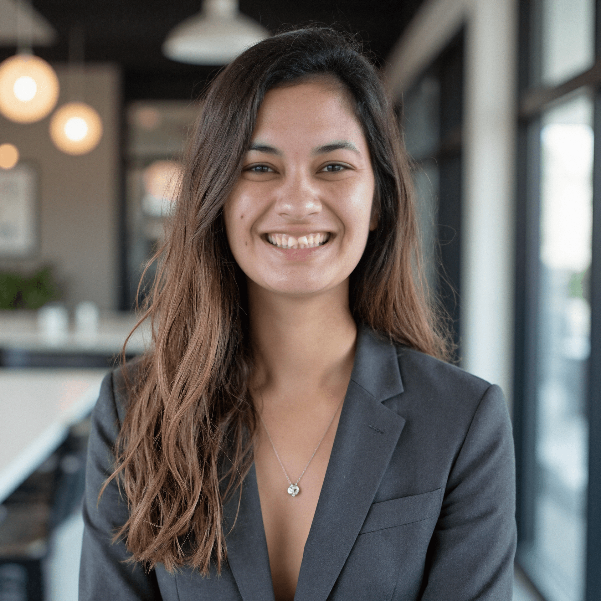 Me wearing a dark blazer in front of a modern building