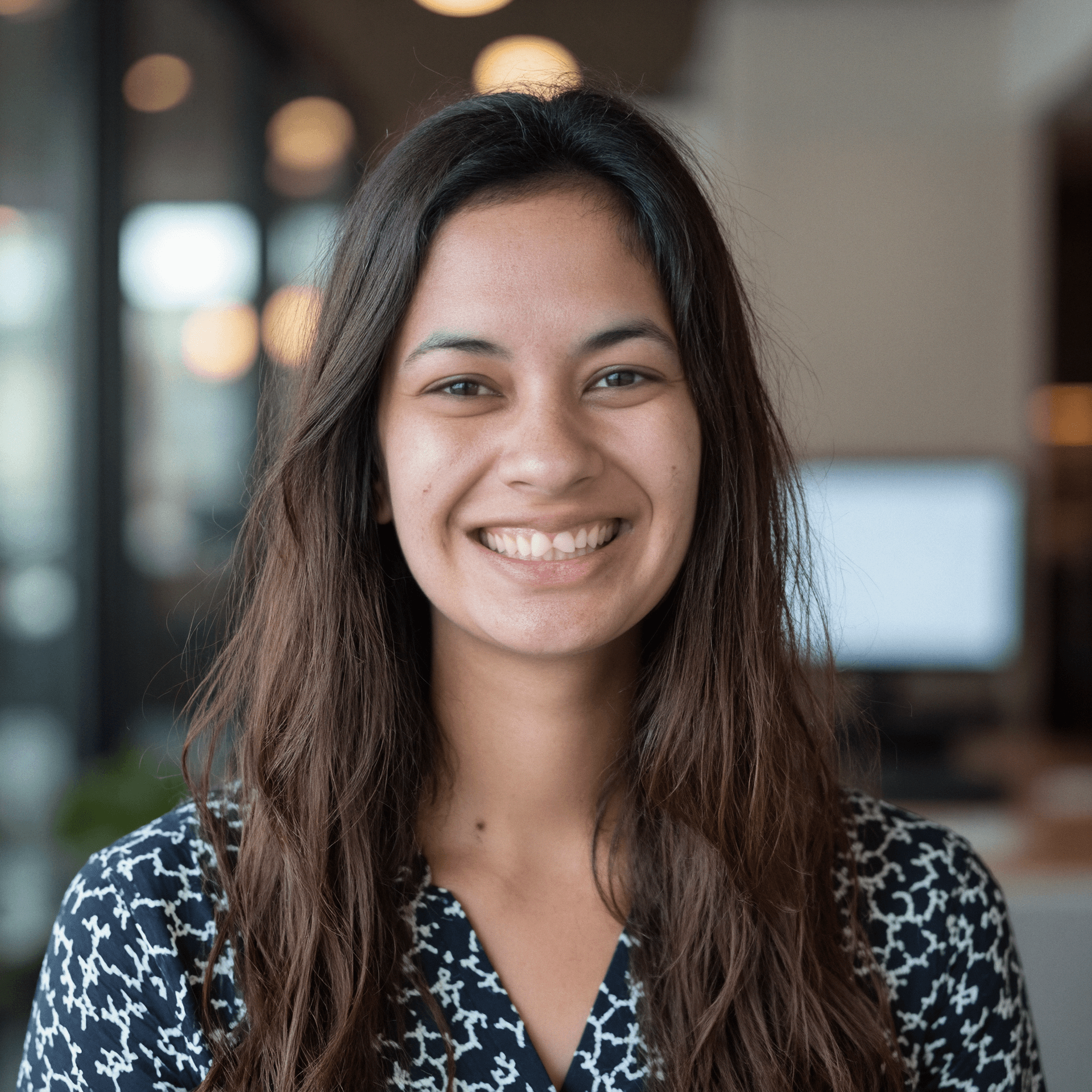 A professional portrait of myself smiling in front of a modern office