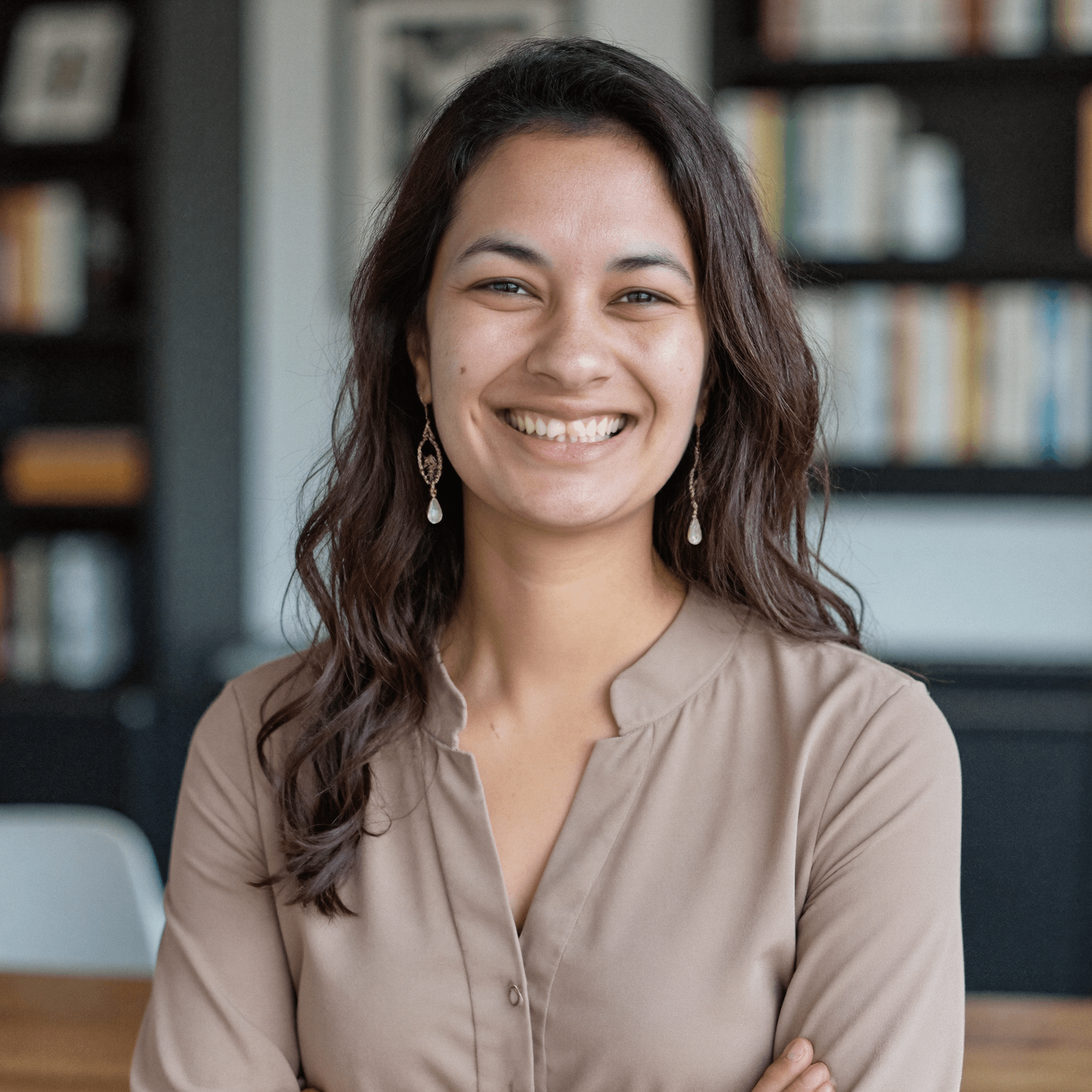 A professional portrait of Soureya smiling in a modern office